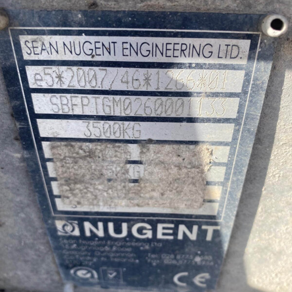 Metal nameplate on a dusty machine reading 'SEAN NUGENT ENGINEERING LTD' with serial/model numbers partially legible beneath the company name.