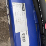 Close-up of a blue metal surface with a silver label showing the brand 'DALBO' and a barcode.