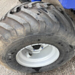 Close-up of a rugged off-road tire with deep, dusty tread.