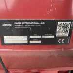 Label on red machinery: Hardi International A/S with QR code and company details (Denmark).