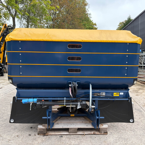 Front view of a blue trailer with a bright yellow tarp cover secured by straps, placed on a wooden pallet outdoors.
