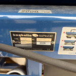 Close-up of a blue agricultural machine with a metal data plate showing model L20 and year 2026, Made in Denmark.