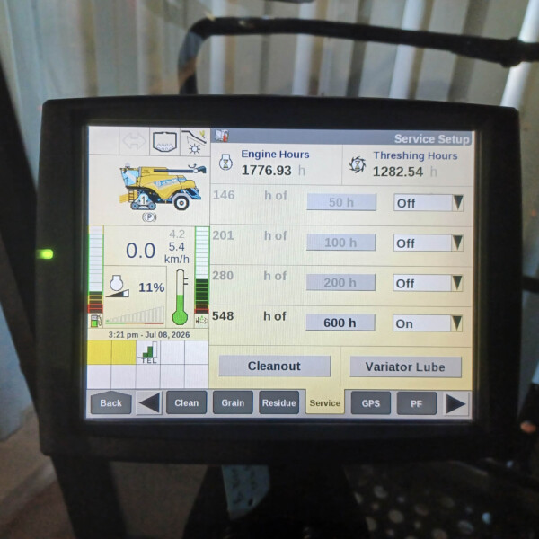 Close-up of a machine display showing engine hours (1776.93 h) and threshing hours (1282.54 h) with control buttons and a yellow harvesting icon on the left, labeled 'Service Setup'.