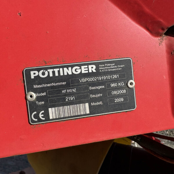 Close-up of a black nameplate on red machinery showing the PÖTTINGER logo, model HIT 810 NZ, serial/VB number, and weight details (960 kg).