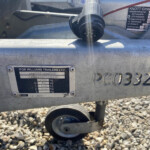 Close-up of a trailer hitch and identification plate on an Ifor Williams trailer, with gravel beneath the scene.