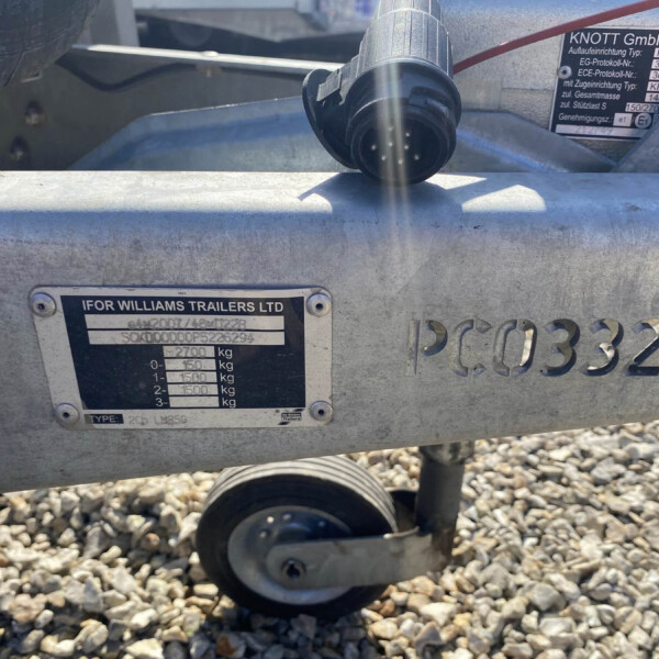 Close-up of a trailer hitch and identification plate on an Ifor Williams trailer, with gravel beneath the scene.