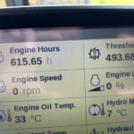 Dashboard panel displaying engine hours 615.65 h and threshing hours 493.68 h with icons nearby.