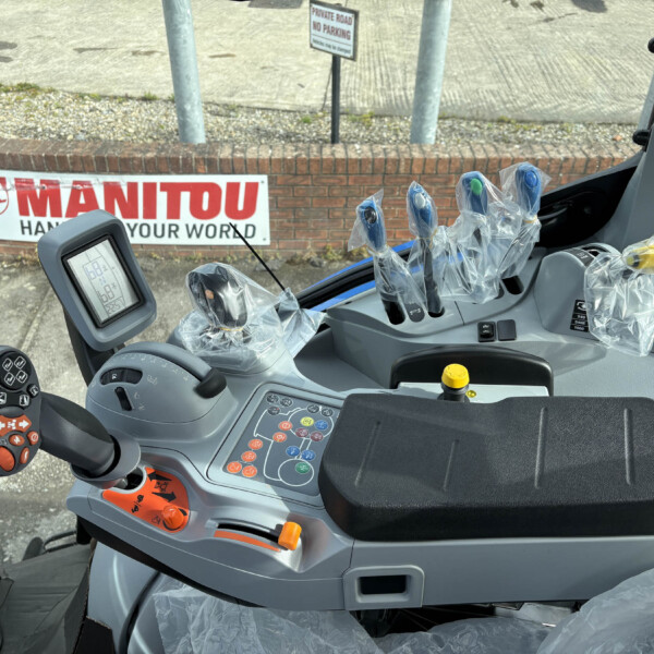 Inside a Manitou forklift cab: plastic-wrapped joysticks, control panel, and display monitor
