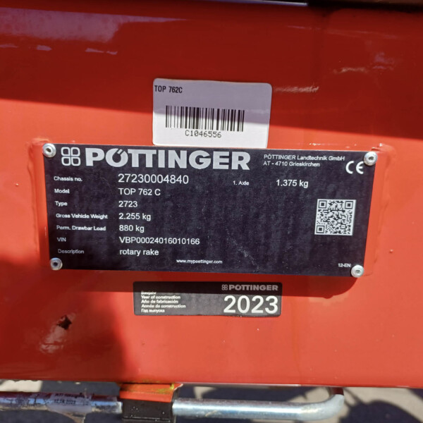 Identification label on orange agricultural equipment: Pöttinger TOP 762C with model and serial details.
