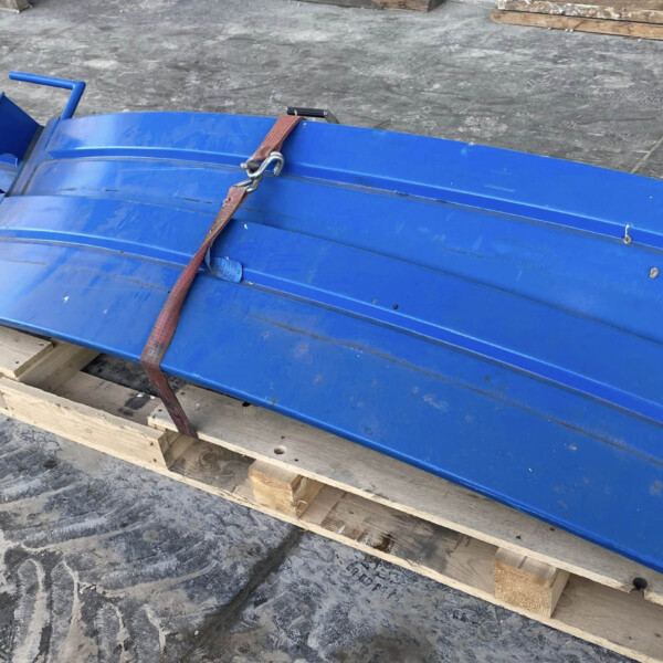 Blue metal beam or duct strapped to a wooden pallet with a red ratchet strap. haqq?