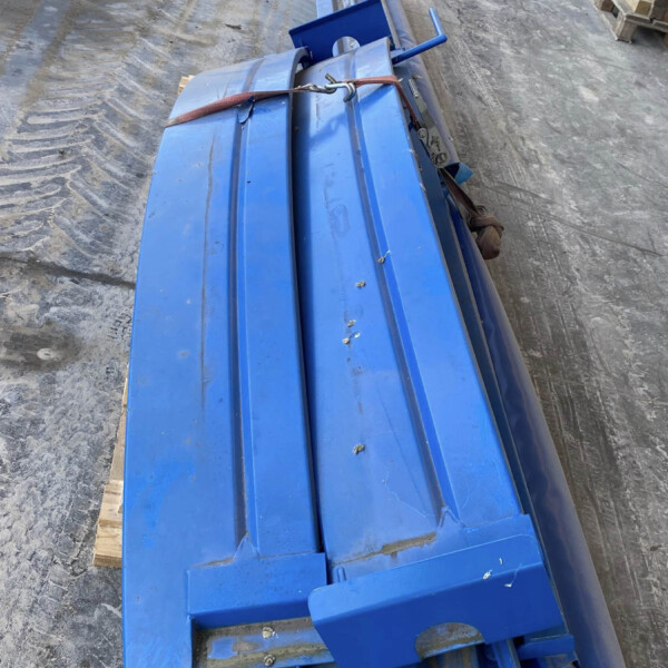 Blue metal industrial framework tied with a red strap, on a concrete warehouse floor.