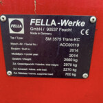 Metal identification plate on a red surface showing model, serial, year, and weight specs (German/English). Accuracy: FELLA-Werke label with types and weights visible.