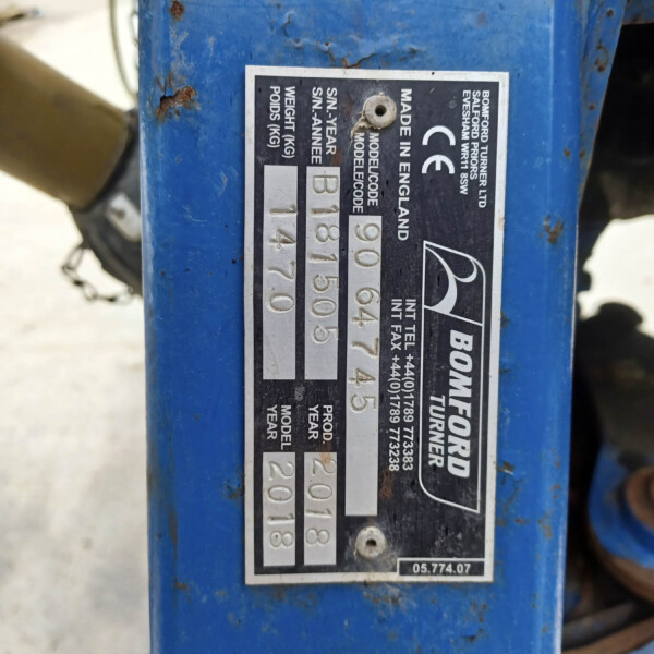 Close-up of a blue industrial machine's metal identification plate showing model/serial numbers and weight (weighs 54 kg).