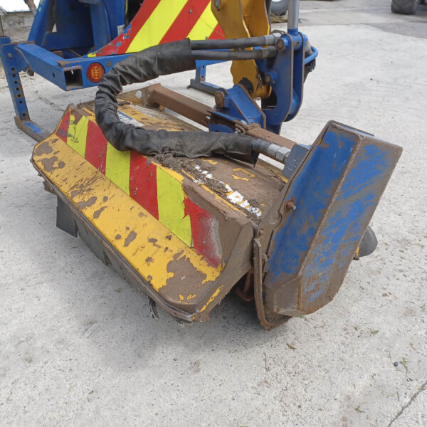Close-up of a weathered construction bucket with yellow and red chevron safety markings and blue metal framework, showing worn paint and hydraulic hoses.
