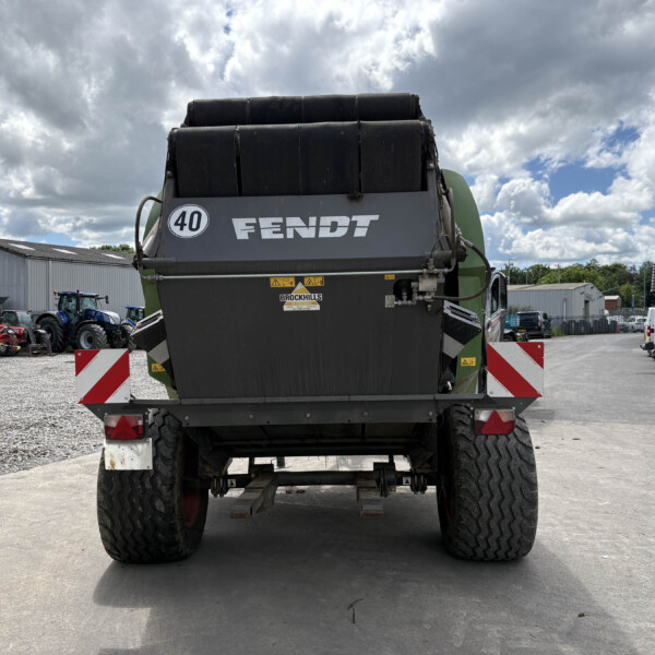 Rear view of a large green Fendt agricultural machine with oversized tires in a farm equipment yard, 40 badge visible.
