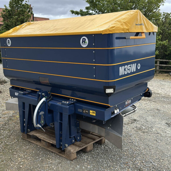 Blue skid-mounted generator with a yellow tarp cover outdoors, on a wooden pallet, featuring orange trim and M35W branding.