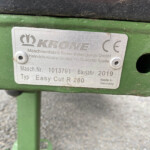 Close-up of a metal nameplate on green machinery with Krone logo and German text, including model and serial details (Made in Germany).