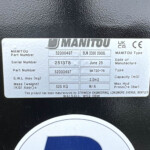 Close-up of a metal data plate on a black surface showing MANITOU branding, part numbers, serial number 251378, date June 25, and capacity 2.0 m3.