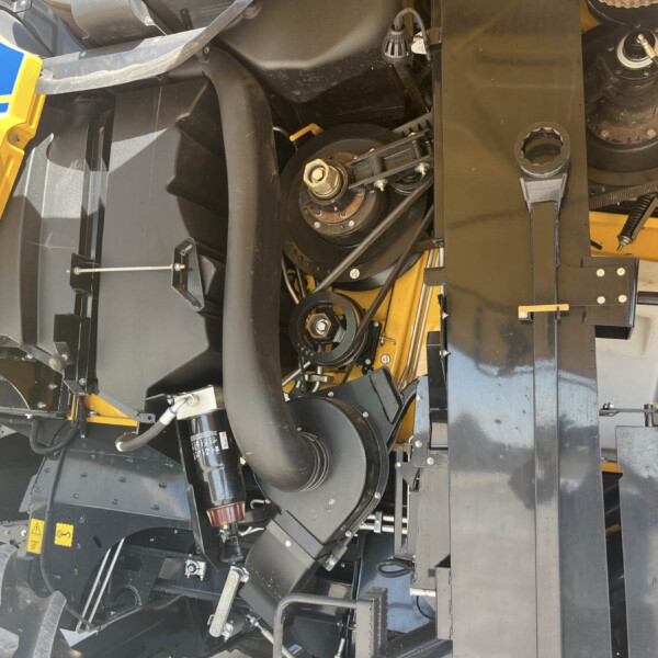 Close-up of heavy industrial machinery interior with gears, belts and yellow safety panels in view.