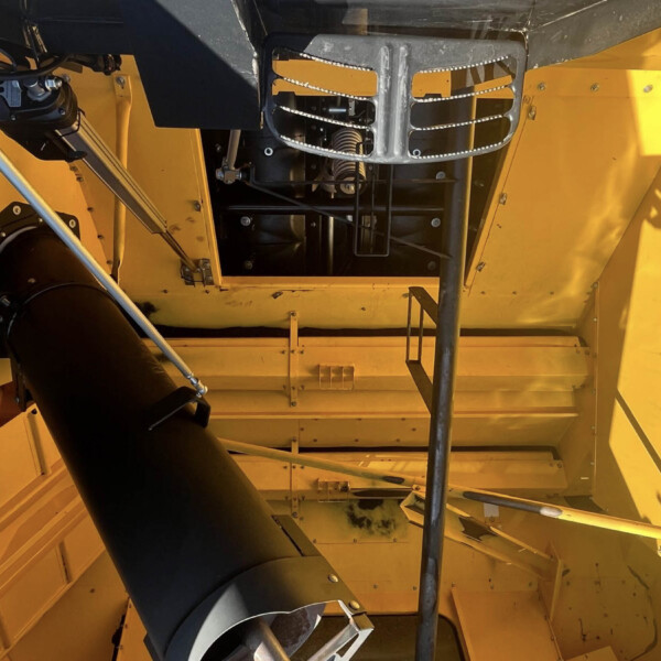 Interior of a large yellow industrial machine showing black ducting, metal frames, and exposed components visible through panels.