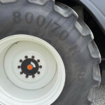 Close-up of a large tractor tire and white rim, showing lug bolts arranged around the center and the 800/70R tire markings on the sidewall