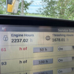 Tractor maintenance screen showing Engine Hours (2237.02 h) and Threshing Hours (1678.01 h) with a Service Setup tab visible.