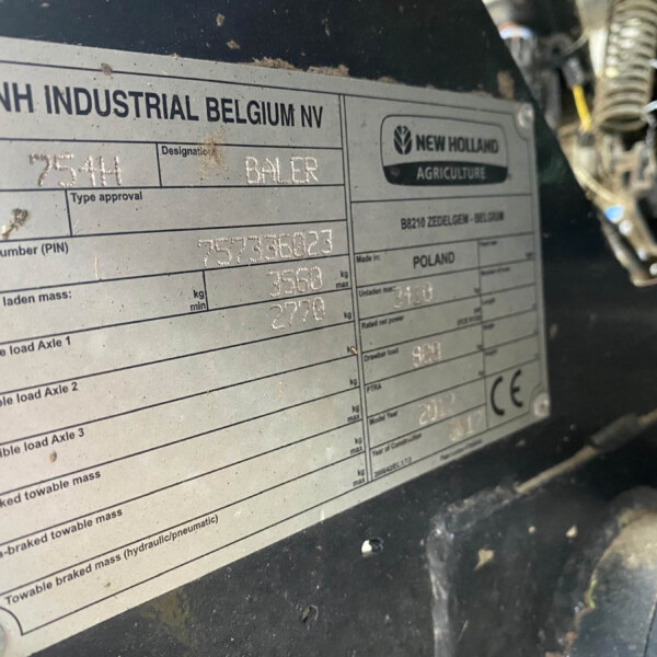 Metal machinery identification plate with CNH Industrial Belgium NV and New Holland Agriculture logo, showing model and serial fields.