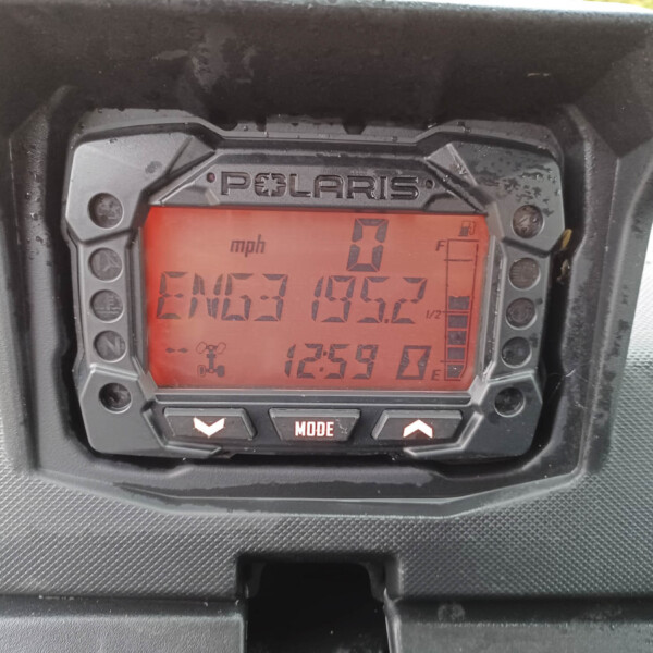 Polaris digital instrument panel with a red backlit display showing 0 mph and gauge icons inside a rugged black housing.