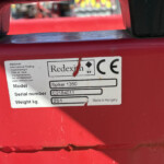 Close-up of red machinery with a white label: Redexim Spiker 1350, serial C2184011, 251 kg, Made in Hungary.
