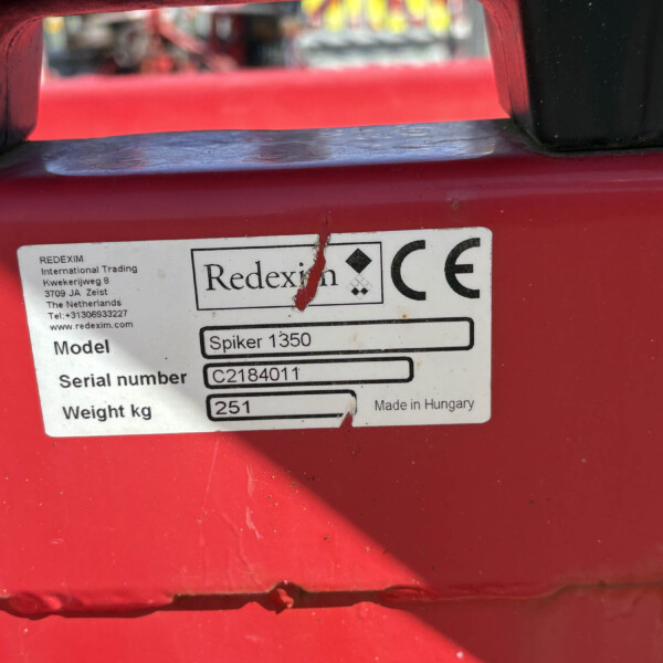 Close-up of red machinery with a white label: Redexim Spiker 1350, serial C2184011, 251 kg, Made in Hungary.