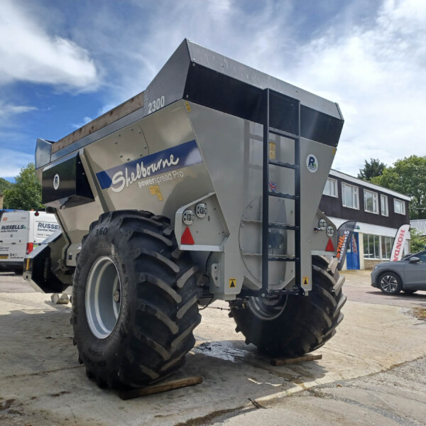 Shelbourne Powerspread Pro large agricultural spreader with big tires in an outdoor yard.
