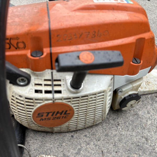 Close-up of an orange STIHL MS 261 chainsaw body, showing the gas tank area and vented front panel.