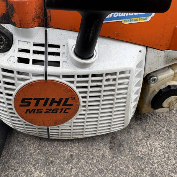 Close-up of a STIHL MS 261C gas-powered chainsaw with orange housing and white body, showing the brand badge on the front.