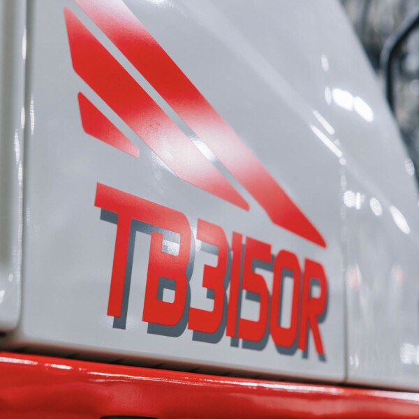 Close-up of a gray vehicle door with bold red 'FIRE' lettering and a red emergency light bar at the bottom, suggesting a fire department vehicle.