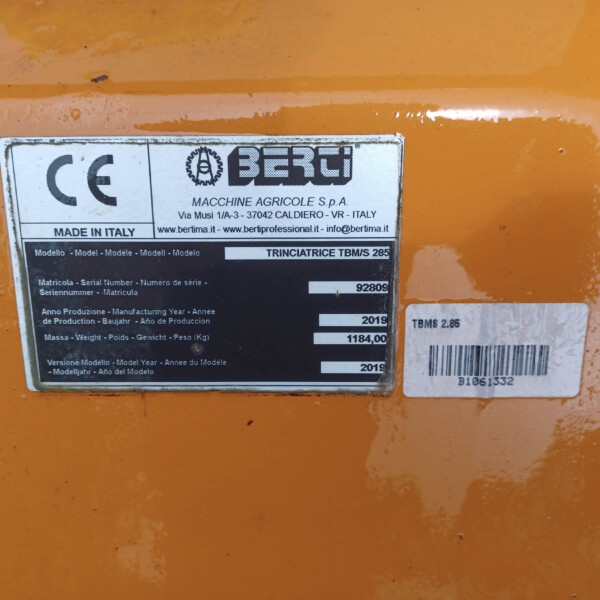 Close-up of an orange machine's metal nameplate showing the CE mark, Made in Italy, and model TBMS 285.