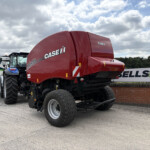 Red Case IH agricultural header on display with large tires in an outdoor lot.