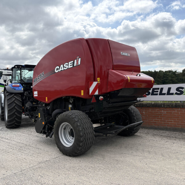 Red Case IH agricultural header on display with large tires in an outdoor lot.