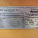 Metal identification plate on an orange machine showing 'CNH Industrial Italia S.p.A. Made in Italy' and the New Holland Construction logo with model and serial information visible beneath.