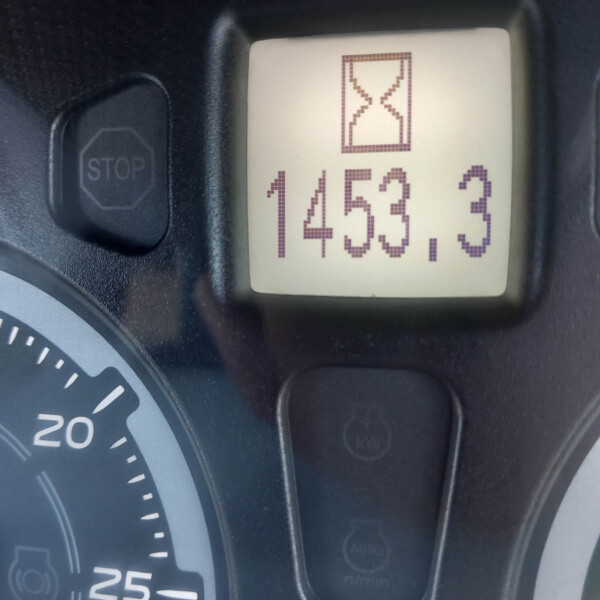 Close-up of a car dashboard showing a digital timer with an hourglass icon and the value 1453.3. Nearby is the STOP button on the steering console.