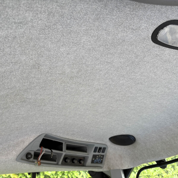Overhead console of a vehicle ceiling with exposed wiring and empty slots from a removed panel