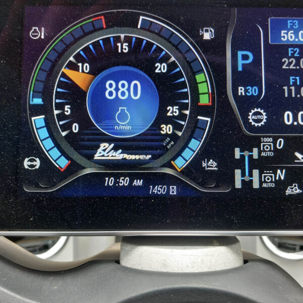 Digital car tachometer showing engine speed around 880 rpm in a blue center, with gear indicator in P on the right and fuel gauge nearby.