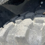 Close-up of gray interlocking concrete blocks forming a shoreline breakwater structure.