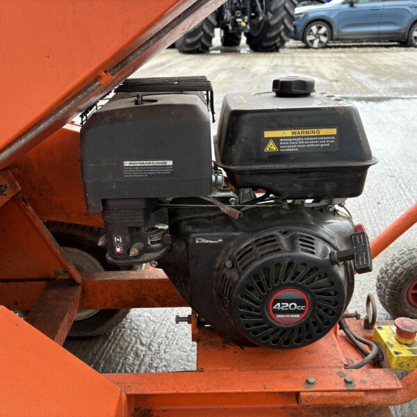 Close-up of an orange machine frame with a black 420cc gasoline engine and warning label.