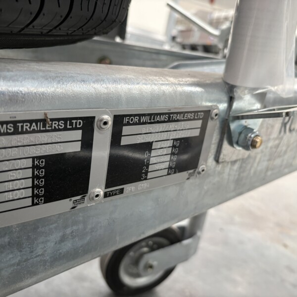 Close-up of a silver trailer frame with a data plate that reads 'FOR WILLIAMS TRAILERS LTD' and shows weight information on the badge.