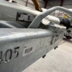 Close-up of a gray metal industrial machine with a barcode label and the model number GX84 visible on the side.