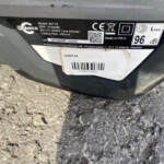 Product label on a lawn trimmer showing model 82T10, 1000W power, 400mm cutting path, and barcode/serial info.