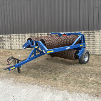 Blue Dal-Bo MINIMAX 630 roller attachment on a wheeled frame near a gray metal wall.