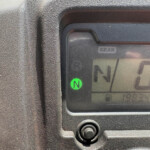 Close-up of a vehicle gear indicator showing Neutral (N) with a green light on the display area of the dashboard.