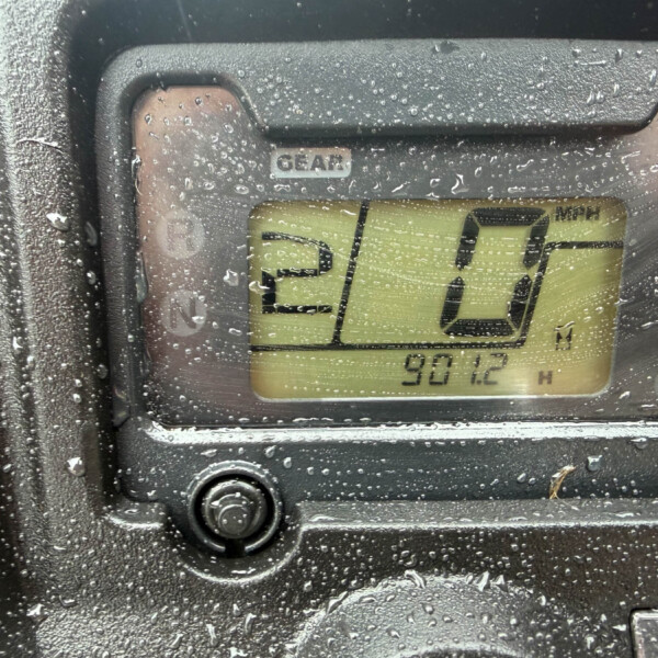 Close-up of a car gear indicator showing the number 0 with raindrops on the dashboard.