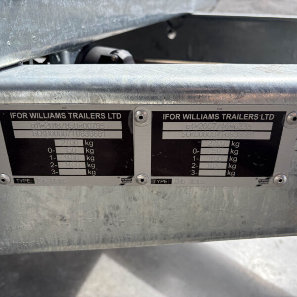 Close-up of a trailer's identification plates on a metal frame, showing 'IFOR WILLIAMS TRAILERS LTD' and weight specifications.